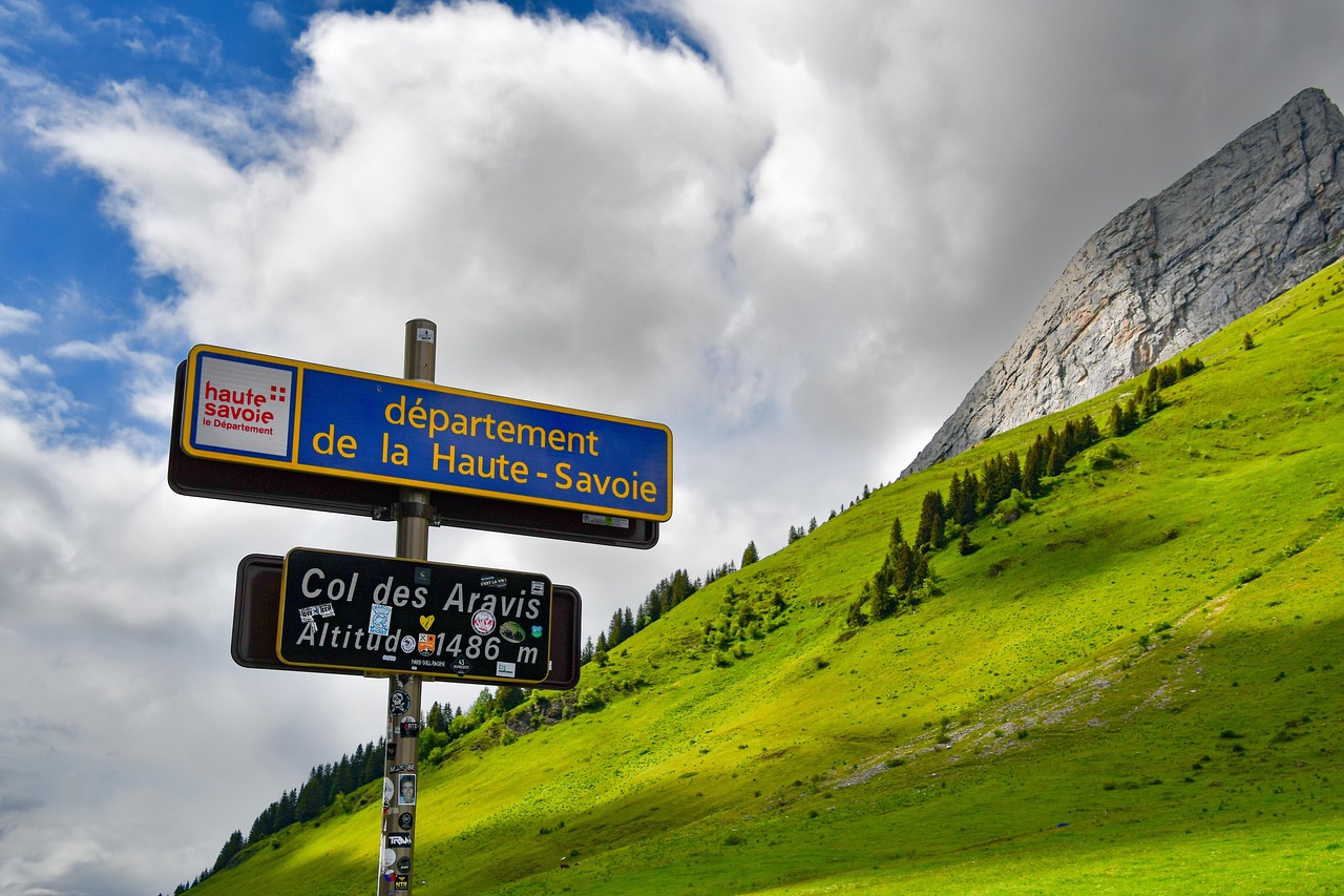 Le panneau du col des Aravis devant les alpages verdoyants.